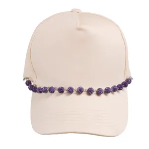 Beige baseball cap decorated with shiny purple rhinestone chain, trendy accessory.