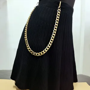 Chunky gold metal waist chain detail, punk style pants accessory for women, edgy fashion look.