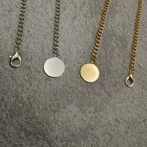 Metal chain jewelry detail view, featuring gold and silver tones with round pendant design.