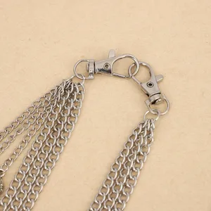 Detailed close-up of multi-layer silver metal chain, punk style trouser and waist chain accessory.