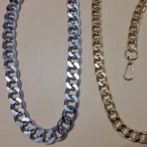 Close-up of punk style metal chains, featuring silver thick chain and gold chain with clasp.