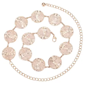 Primo piano della cintura a catena in metallo oro rosa con medaglioni circolari goffrati.
