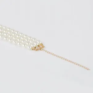 Detail shot of the multi-layer faux pearl necklace clasp and gold extension chain.