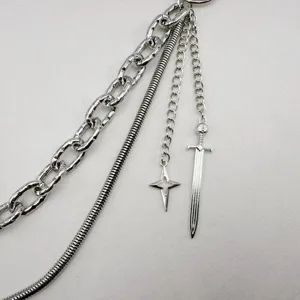 Primo piano della catena da cintura in metallo punk con ciondoli spada e stella, colore argento.