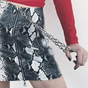 Punk style metal chain waist chain and snakeskin skirt detail shot for fashion look.