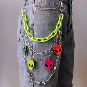 Close-up of punk style multi-layer pants chain with neon green links and alien pendants.