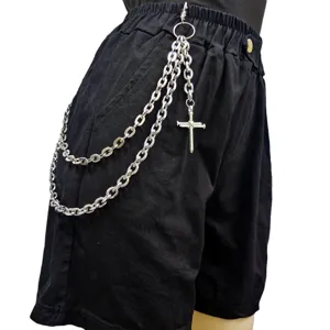Punk style multi-layer metal waist chain with cross pendant and black shorts for street fashion.