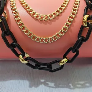 Close-up detail shot of punk hip-hop chunky black and gold layered chain jewelry decoration.