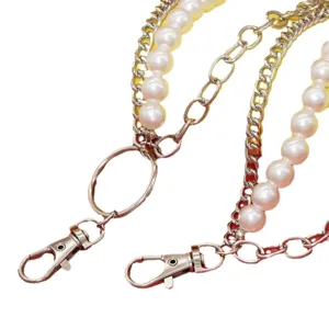 Close-up detail shot of multi-layer metal chain with faux pearls, lobster clasps, and rings.