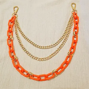 Details of the multi-layer punk hip-hop orange resin and gold metal chain accessory.
