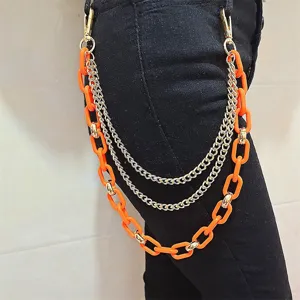 Close-up detail of punk multi-layer acrylic and metal pants chain accessory for street style outfit.