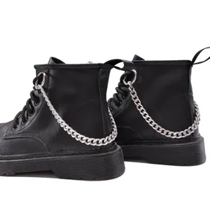 Detailed shot of black combat boots featuring stylish silver metal chain accessories and chunky heels.