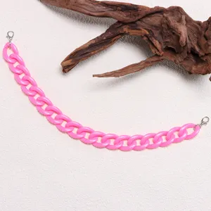 Pink chunky resin chain link detail, vibrant color bag or hat accessory component closeup.