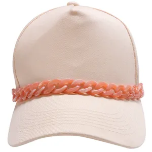 Chunky pink chain detail and fine canvas texture close-up for stylish baseball cap accessorizing.