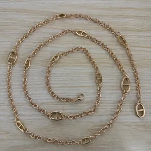Gros plan sur la belle ceinture chaîne en métal doré dotée de maillons d'ancre élégants.