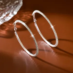 Dettaglio di orecchini a cerchio scintillanti in cristallo, grande design circolare argentato.