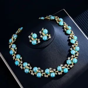 Vue rapprochée d'un ensemble de bijoux luxueux en perles bleues et strass de feuilles d'or.