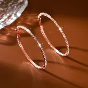 Primo piano di eleganti orecchini a cerchio in strass oro rosa scintillanti dettagli.