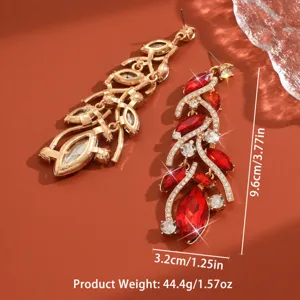 Dettaglio di orecchini lunghi con cristalli rossi e design di strass di lusso raffinati.