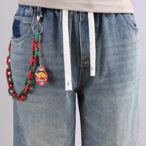 Close-up detail of trendy hip-hop Christmas themed pants chain accessory with red green links.