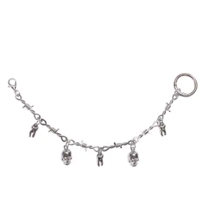 Close-up detail view of punk silver skull and tooth charms chain with barbed wire links.