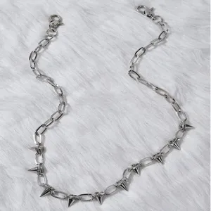 Detalle de cadena de metal plateado estilo punk, con colgantes de picos para looks audaces.