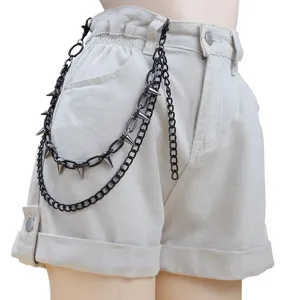 Shorts vaqueros beige de estilo punk combinados con una cadena de cintura de tachuelas de metal negro.