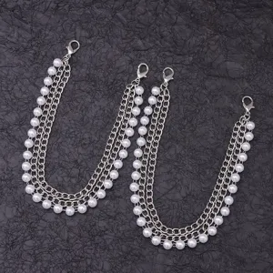 Nahaufnahme von mehrlagigen Perlen- und Metallketten-Schuhaccessoires mit Karabinerhaken.