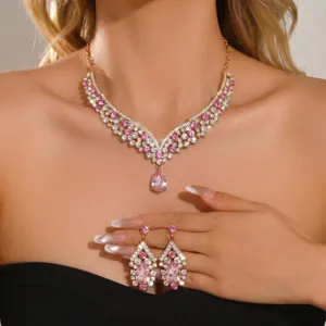 Detailed close-up of pink crystal rhinestone necklace and matching drop earrings set.