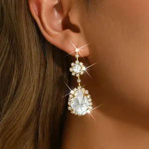 Gros plan détaillé de boucles d'oreilles pendantes strass floral avec cristaux scintillants.