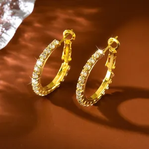 Eleganti orecchini a cerchio dorati con zirconi brillanti in primo piano dettagliato.