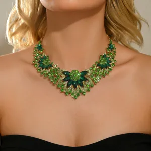 Close-up detail of a glamorous green crystal rhinestone flower statement necklace sparkling.