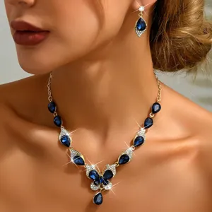 Primo piano dettagliato ed elegante della collana con farfalla in cristallo blu e orecchini.