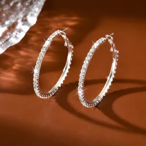 Primo piano dettagliato di orecchini a cerchio con strass brillanti, stile festa alla moda.