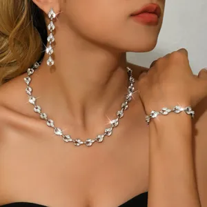 Dettaglio di gioielli in cristallo scintillante con pietre su collana, orecchini e bracciale.