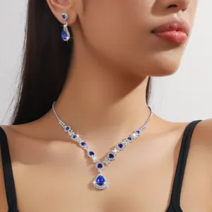 Primo piano dettagliato di una collana con pietre blu a goccia e orecchini coordinati.