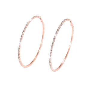 Primo piano di orecchini a cerchio in strass oro rosa con dettagli in cristallo scintillante e metallo.