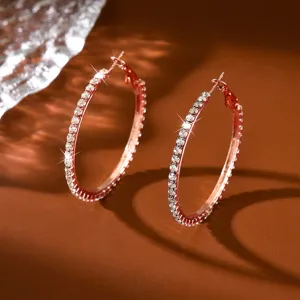 Primo piano dettagliato di orecchini a cerchio con strass scintillanti in oro rosa.