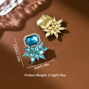 Boucles d'oreilles statement fleur en cristal luxueux avec verre bleu et strass brillants.