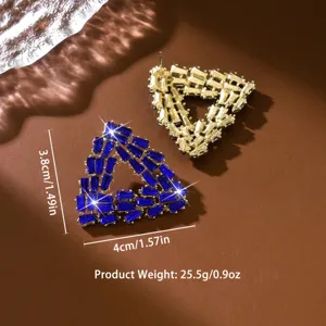 Boucles d'oreilles triangulaires en cristal géométrique avec strass bleus et métal doré.