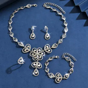 Elegante juego de joyas plateadas con estrás de flores, collar, pendientes, pulsera y anillo.