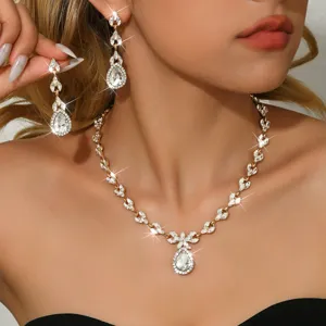 Close-up detail of luxurious crystal teardrop necklace and earrings set worn by model.