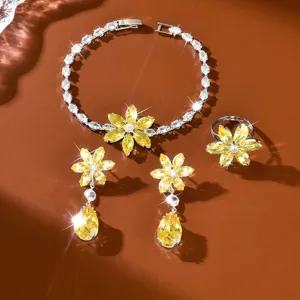 Gros plan sur la parure de bijoux fleur en cristal jaune avec bracelet, boucles et bague.