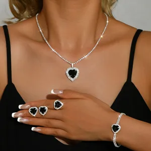 Primo piano della scintillante parure di gioielli con cuore nero, collana e anello.