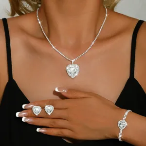 Dettaglio di parure di gioielli con scintillante collana, orecchini e bracciale a cuore.