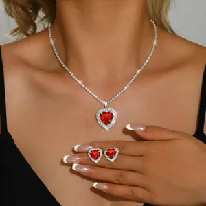 Vista dettagliata di collana e orecchini con cuore rosso e design di zirconi lucidi.