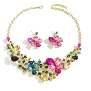 Primo piano dettagliato di set collana e orecchini farfalla fiore cristallo colorato oro.