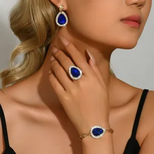 Set di gioielli eleganti con pietra blu a forma di pera, orecchini, anello e bracciale.