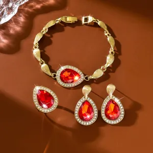 Set di gioielli in cristallo rosso con braccialetto dorato e orecchini coordinati.