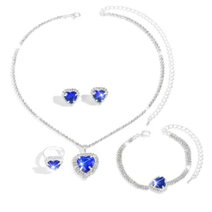 Dettaglio set gioielli con cristallo blu a cuore e strass luminosi per collana e bracciale.